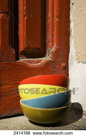 Colourful bowls in a pile beside a weathered red painted wooden door; Barcelona, Spain View Large Photo Image Stock Photograph - Colourful bowls in a pile beside a weathered red painted wooden door; Barcelona, Spain. Fotosearch