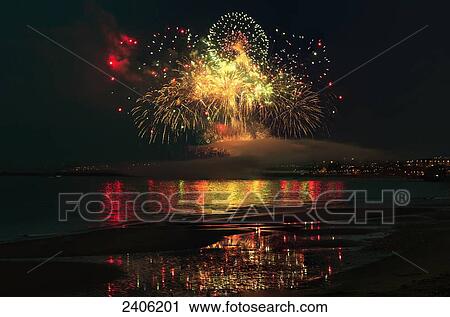 Stock Image - Colourful fireworks display reflected on the water; Sunderland, Tyne and Wear, England. Fotosearch