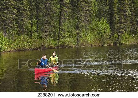 Couple in red canoe on Byers Lake with green tree covered shoreline in the background, Denali State Park; Alaska, Alaska, United States of America View Large Photo Image Stock Image - Couple in red canoe on Byers Lake with green tree covered shoreline in the background, Denali State Park; Alaska, Alaska, United States of America. Fotosearch