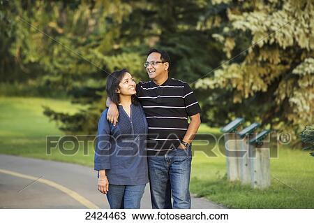 Stock Image - Couple walking and spending quality time together in a park in autumn; Edmonton, Alberta, Canada. Fotosearch