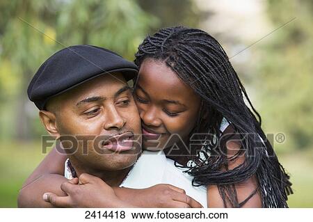 Stock Photo - Daughter hugging her father in a park; Edmonton, Alberta, Canada. Fotosearch