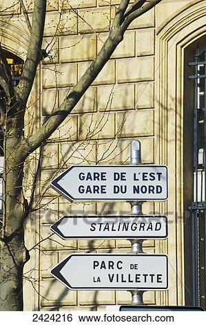 Stock Photograph - Destination signs outside a building; Paris, France. Fotosearch
