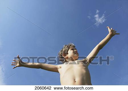 Stock Image - Eight Year Old Boy With Arms Outstretched, Winnipeg, Canada. Fotosearch