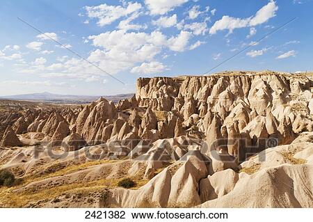 Stock Image - Fairy chimneys and cliffs in a rugged, barren landscape in Deverent Valley; Cappadocia, Turkey. Fotosearch
