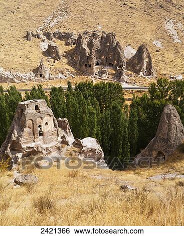 Fairy chimneys and trees in an arid landscape; Goreme, Cappadocia, Turkey View Large Photo Image Stock Photograph - Fairy chimneys and trees in an arid landscape; Goreme, Cappadocia, Turkey. Fotosearch