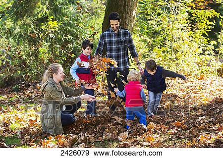 Family throwing leaves in the air at a park in autumn; Langley, British Columbia, Canada View Large Photo Image Stock Photo - Family throwing leaves in the air at a park in autumn; Langley, British Columbia, Canada. Fotosearch