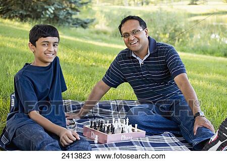 Father and son playing chess in a park; Edmonton, Alberta, Canada View Large Photo Image Stock Image - Father and son playing chess in a park; Edmonton, Alberta, Canada. Fotosearch