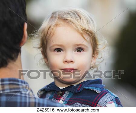 Stock Photograph - Father carrying his young son; Langley, British Columbia, Canada. Fotosearch