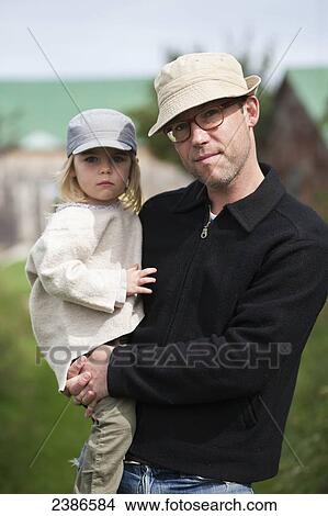Picture - Father holds daughter in the countryside in autumn; Ontario, Canada. Fotosearch