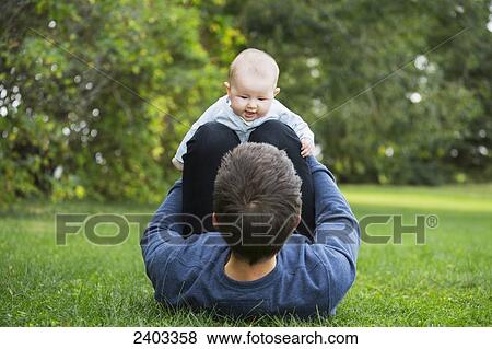Stock Photo - Father spending quality time with his infant daughter; Edmonton, Alberta, Canada. Fotosearch