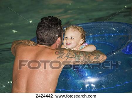 Father swimming with toddler in inflatable tube in a pool; St. Albert, Alberta, Canada View Large Photo Image Stock Image - Father swimming with toddler in inflatable tube in a pool; St. Albert, Alberta, Canada. Fotosearch