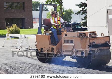 Female operator driving steam roller repairing pot holes in a parking lot; Edmonton, Alberta, Canada View Large Photo Image Stock Image - Female operator driving steam roller repairing pot holes in a parking lot; Edmonton, Alberta, Canada. Fotosearch