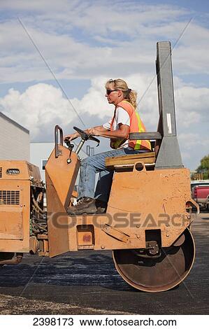 Female operator driving steam roller repairing pot holes in a parking lot; Edmonton, Alberta, Canada View Large Photo Image Stock Image - Female operator driving steam roller repairing pot holes in a parking lot; Edmonton, Alberta, Canada. Fotosearch
