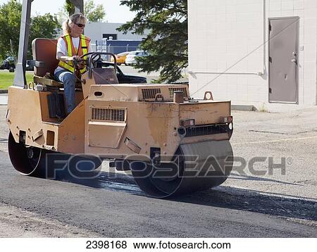 Female operator driving steam roller repairing pot holes in a parking lot; Edmonton, Alberta, Canada View Large Photo Image Stock Photo - Female operator driving steam roller repairing pot holes in a parking lot; Edmonton, Alberta, Canada. Fotosearch
