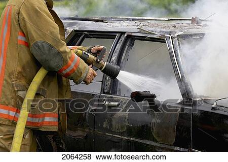 Fire Fighter Putting Out Car Fire With Hose, Smithville, Ontario View Large Photo Image Stock Photo - Fire Fighter Putting Out Car Fire With Hose, Smithville, Ontario. Fotosearch