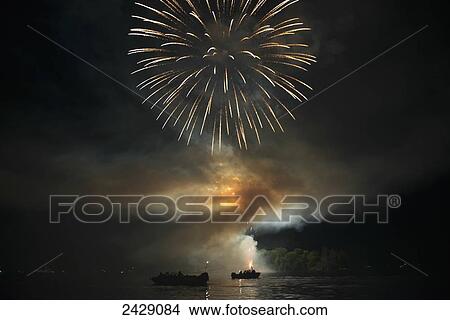 Fireworks display over a lake illuminating the boats on the water; Kenora, Ontario, Canada View Large Photo Image Picture - Fireworks display over a lake illuminating the boats on the water; Kenora, Ontario, Canada. Fotosearch