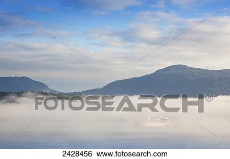 Fog surrounds a freighter anchored in Cowichan Bay off Vancouver Island; Duncan, British Columbia, Canada View Large Photo Image Stock Photograph - Fog surrounds a freighter anchored in Cowichan Bay off Vancouver Island; Duncan, British Columbia, Canada. Fotosearch