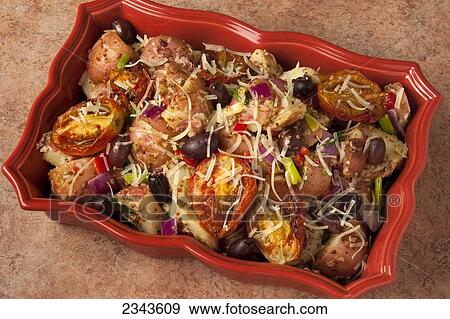 Stock Photo - Food - Baked red potatoes with sun-dried tomatoes, Kalamata olives, red onions, red bell pepper, green onions (scallions) and grated Parmesan cheese.. Fotosearch