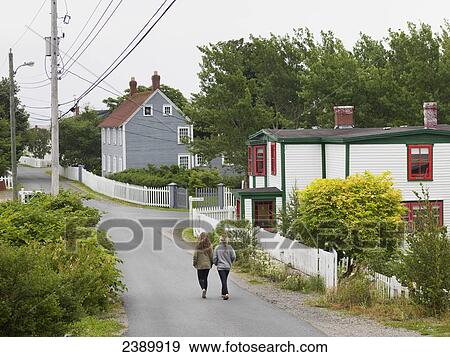 Friends walking down the street together; Trinity, Newfoundland and Labrador, Canada View Large Photo Image Stock Photo - Friends walking down the street together; Trinity, Newfoundland and Labrador, Canada. Fotosearch