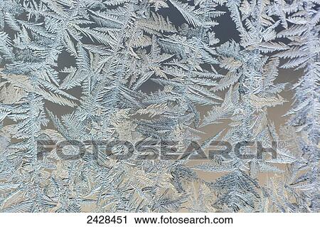 Stock Image - Frost patterns are captured on a frosted window pane in the early morning on Vancouver Island; Duncan, British Columbia, Canada. Fotosearch