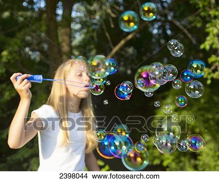 Girl blowing bubbles in the park; Edmonton, Alberta, Canada View Large Photo Image Picture - Girl blowing bubbles in the park; Edmonton, Alberta, Canada. Fotosearch