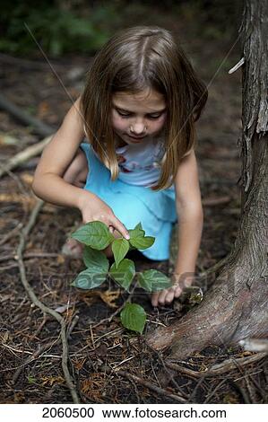 Stock Image - Girl Pointing At Plant In Rainforest, Camaguey, Cuba. Fotosearch