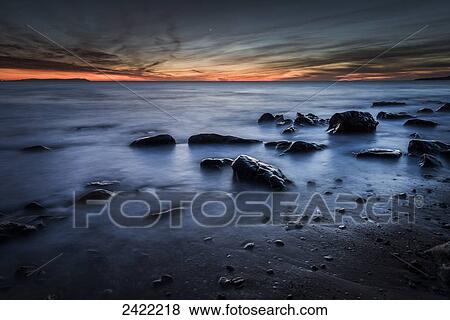 Stock Photo - Glowing orange horizon at sunset over the ocean; Tarifa, Costa de la Luz, Cadiz, Andalusia, Spain. Fotosearch