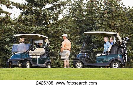 Stock Photo - Golfers talking and getting ready to move to next hole; Edmonton, Alberta, Canada. Fotosearch