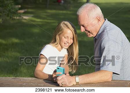 Grandfather and granddaughter checking a mobile device; Edmonton, Alberta, Canada View Large Photo Image Stock Image - Grandfather and granddaughter checking a mobile device; Edmonton, Alberta, Canada. Fotosearch
