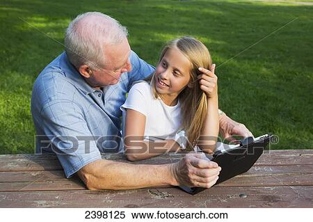 Grandfather and granddaughter checking their mobile devices together; Edmonton, Alberta, Canada View Large Photo Image Stock Photography - Grandfather and granddaughter checking their mobile devices together; Edmonton, Alberta, Canada. Fotosearch