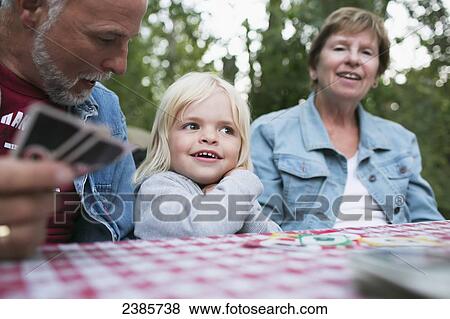 Grandparents playing a card game with a young granddaughter; Peachland, British Columbia, Canada View Large Photo Image Stock Photo - Grandparents playing a card game with a young granddaughter; Peachland, British Columbia, Canada. Fotosearch
