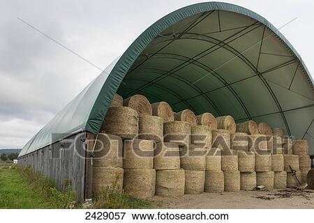 Stock Photo - Hale bales stored in a covered structure; Montebello, Quebec, Canada. Fotosearch
