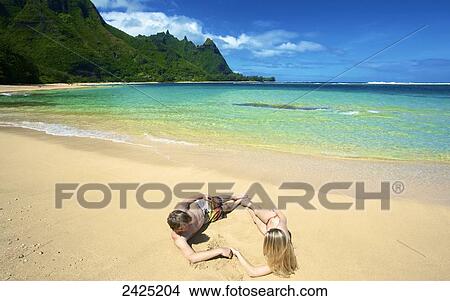 Hawaii, Kauai, Tunnels beach, a young couple makes the shape of a heart. View Large Photo Image Picture - Hawaii, Kauai, Tunnels beach, a young couple makes the shape of a heart.. Fotosearch