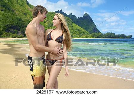 Hawaii, Kauai, Tunnels beach, a young couple embraces on the beach. View Large Photo Image Stock Photo - Hawaii, Kauai, Tunnels beach, a young couple embraces on the beach.. Fotosearch