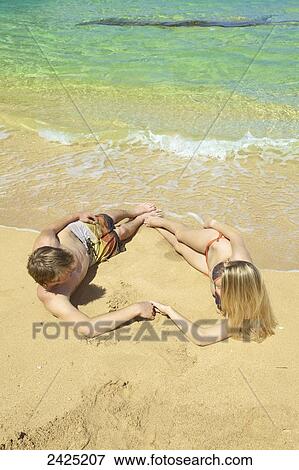 Hawaii, Kauai, Tunnels beach, a young couple makes the shape of a heart. View Large Photo Image Stock Photo - Hawaii, Kauai, Tunnels beach, a young couple makes the shape of a heart.. Fotosearch