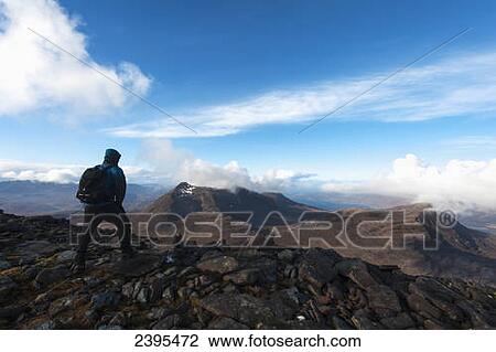 Stock Image - Hiker looking over to Ben Damph from Maol Chean-dearg; Torridon, Scotland,. Fotosearch