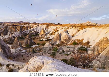 Hot air balloons over a landscape of rugged rock formations and cliffs; Goreme, Cappadocia, Turkey View Large Photo Image Stock Image - Hot air balloons over a landscape of rugged rock formations and cliffs; Goreme, Cappadocia, Turkey. Fotosearch