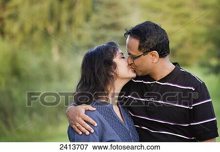 Husband and wife kissing outdoors in a park; Edmonton, Alberta, Canada View Large Photo Image Stock Photo - Husband and wife kissing outdoors in a park; Edmonton, Alberta, Canada. Fotosearch