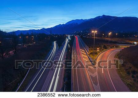 Light trails of vehicle lights on a road at dusk; Locarno, Ticino, Switzerland View Large Photo Image Stock Image - Light trails of vehicle lights on a road at dusk; Locarno, Ticino, Switzerland. Fotosearch
