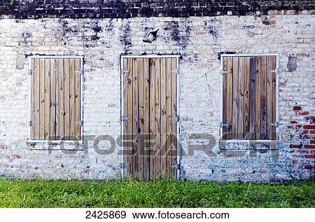 Stock Photo - Louisiana, New Oreleans, Abandoned brick building with wooden doors.. Fotosearch