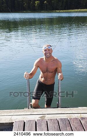 Man getting out of the water onto a dock; Morbylanga, Sweden View Large Photo Image Stock Photograph - Man getting out of the water onto a dock; Morbylanga, Sweden. Fotosearch