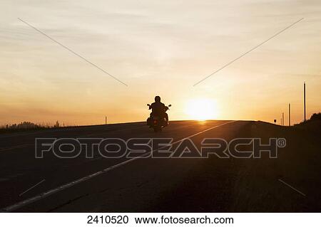 Man on a motorcycle at twilight on a highway, near Edmonton; Alberta, Canada View Large Photo Image Stock Image - Man on a motorcycle at twilight on a highway, near Edmonton; Alberta, Canada. Fotosearch