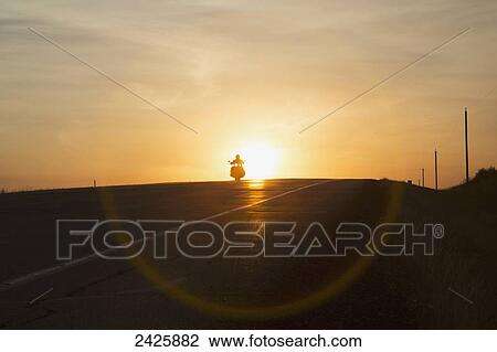 Man riding a motorcycle at sunset on Alberta highway near Edmonton; Alberta, Canada View Large Photo Image Stock Image - Man riding a motorcycle at sunset on Alberta highway near Edmonton; Alberta, Canada. Fotosearch