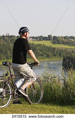 Man riding his electric bicycle with Edmonton city skyline in the background; Edmonton, Alberta, Canada View Large Photo Image Stock Photography - Man riding his electric bicycle with Edmonton city skyline in the background; Edmonton, Alberta, Canada. Fotosearch