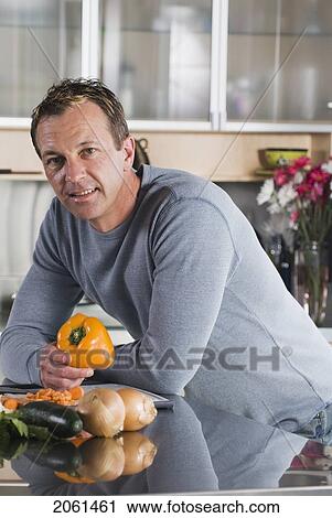 Stock Image - Man With Vegetables In Kitchen, Winnipeg, Canada. Fotosearch