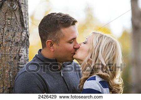 Married couple kissing in a park in autumn; Edmonton, Alberta, Canada View Large Photo Image Stock Photo - Married couple kissing in a park in autumn; Edmonton, Alberta, Canada. Fotosearch