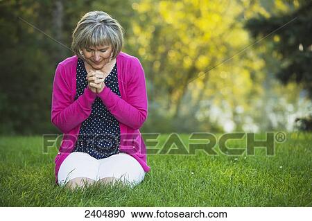 Mature woman praying in the park; Edmonton, Alberta, Canada View Large Photo Image Stock Image - Mature woman praying in the park; Edmonton, Alberta, Canada. Fotosearch
