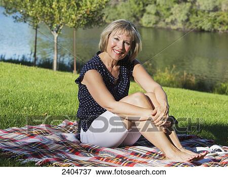 Stock Photo - Mature woman relaxing in Hawrelak Park; Edmonton, Alberta, Canada. Fotosearch