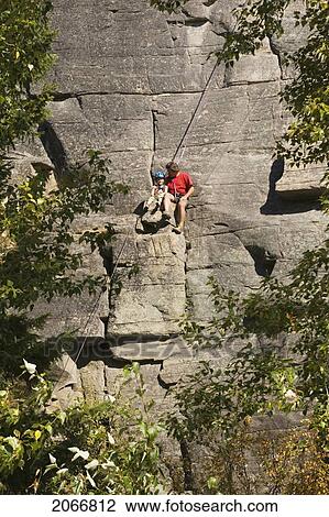 Mid-Age Man Climbing With Daughter (Age 5) Up Granite Cliff At Stone Hills Near Rexford, Montana, Usa View Large Photo Image Stock Image - Mid-Age Man Climbing With Daughter (Age 5) Up Granite Cliff At Stone Hills Near Rexford, Montana, Usa. Fotosearch