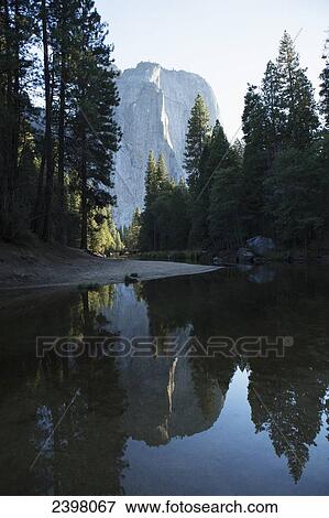 Stock Photo - Mirror image reflection of trees and rock wall in Merced River, Yosemite Valley, Yosemite National Park; California, United States of America. Fotosearch
